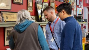 Jacky Chan viewing artifacts at the Scouts Canada National Museum with Liam Burns and another individual.