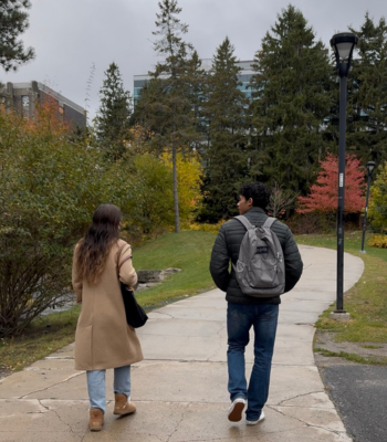 Two students walk the path behind Tory Building on a late fall day.