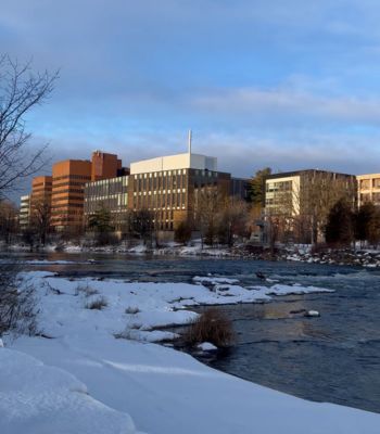 Carleton buildings over the Rideau River on a snowy day.