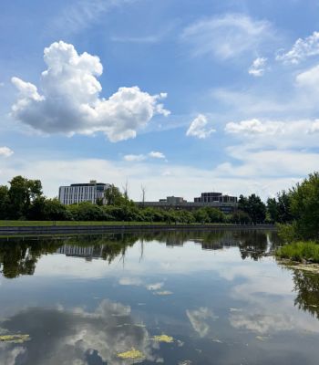 The Rideau Canal on a partly cloudy day with campus Residence buildings in the background.